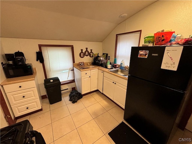 kitchen with black appliances, sink, vaulted ceiling, a baseboard radiator, and white cabinetry