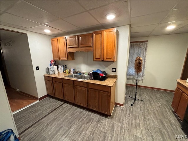 kitchen featuring hardwood / wood-style flooring, a drop ceiling, and sink