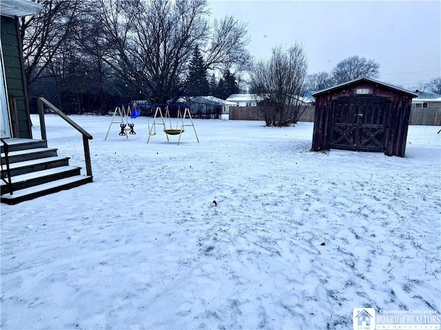 yard layered in snow with a shed