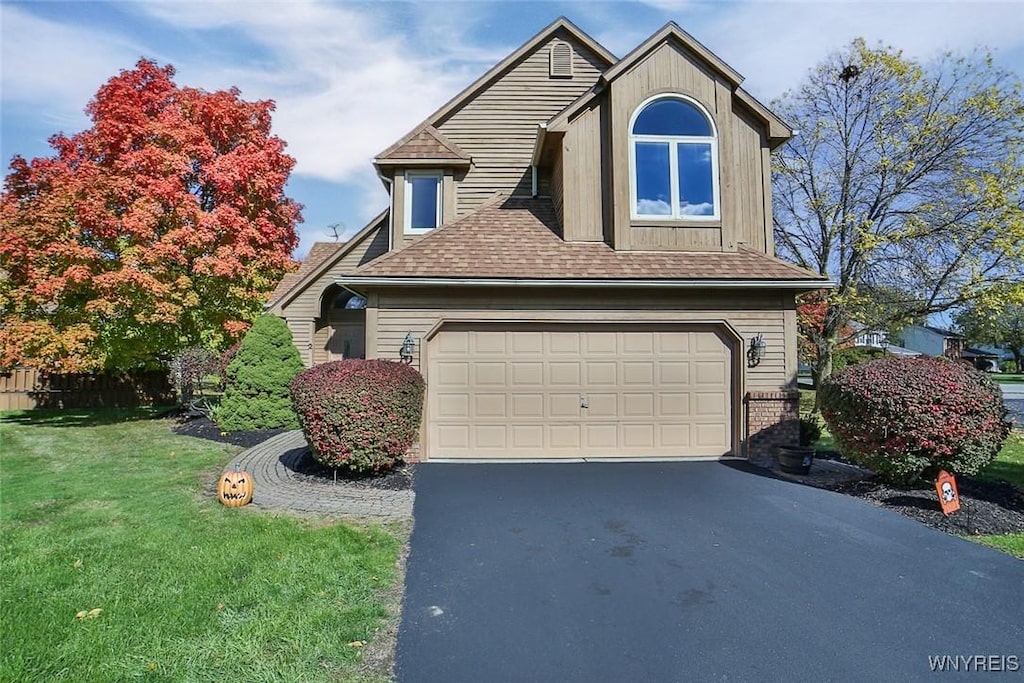 view of front of house featuring a front lawn and a garage