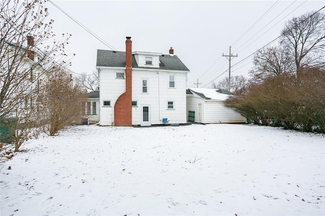 view of snow covered back of property