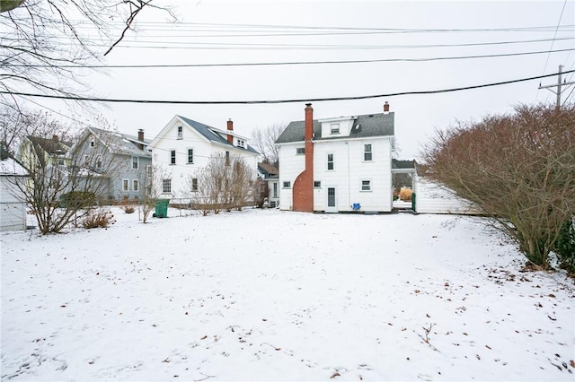 view of snow covered back of property