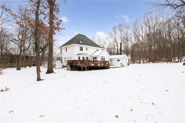 snow covered rear of property with a deck