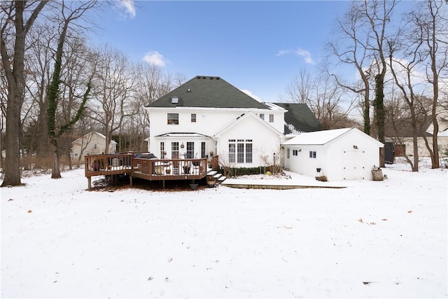 snow covered rear of property featuring a wooden deck and an outdoor structure