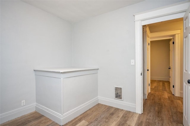 hallway with hardwood / wood-style flooring