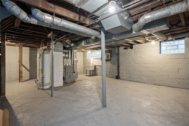 basement featuring gas water heater, sink, and heating unit