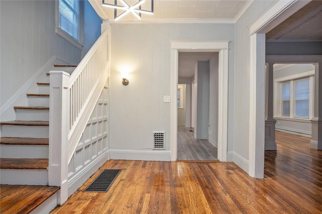 staircase with crown molding and wood-type flooring