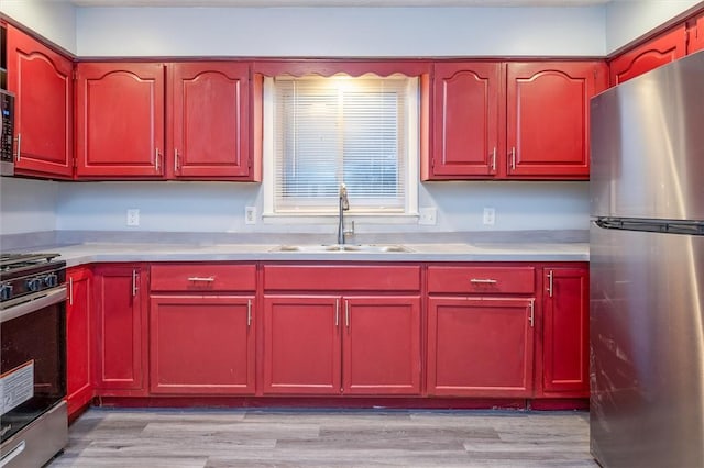 kitchen featuring light wood-type flooring, stainless steel appliances, and sink