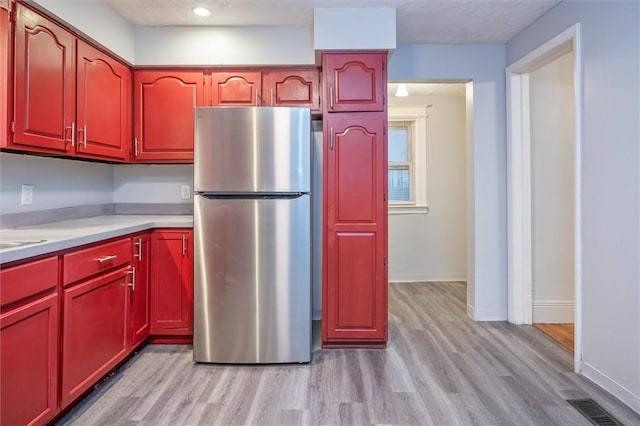 kitchen with light wood-type flooring and stainless steel refrigerator