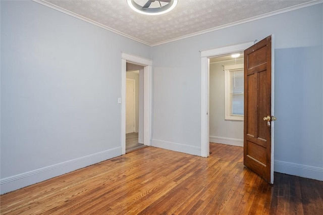 spare room with dark hardwood / wood-style flooring, a textured ceiling, and crown molding