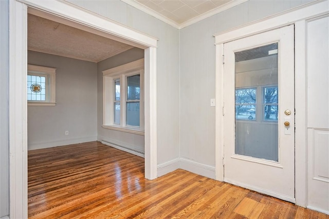 entrance foyer featuring light wood-type flooring, a baseboard radiator, and ornamental molding