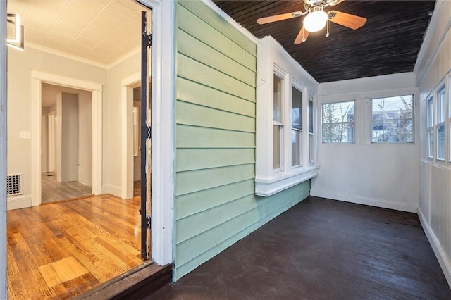 unfurnished sunroom featuring ceiling fan