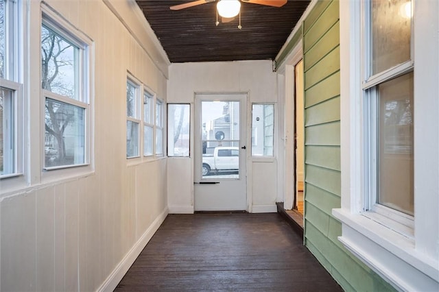 doorway to outside featuring ceiling fan, dark hardwood / wood-style flooring, wood ceiling, and wooden walls