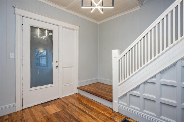 foyer with wood-type flooring and crown molding