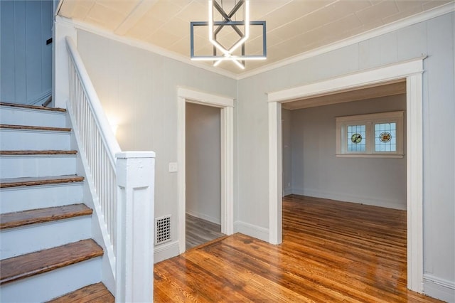 stairway with hardwood / wood-style floors and crown molding