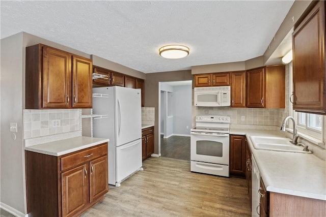 kitchen with sink, light hardwood / wood-style flooring, a textured ceiling, white appliances, and decorative backsplash