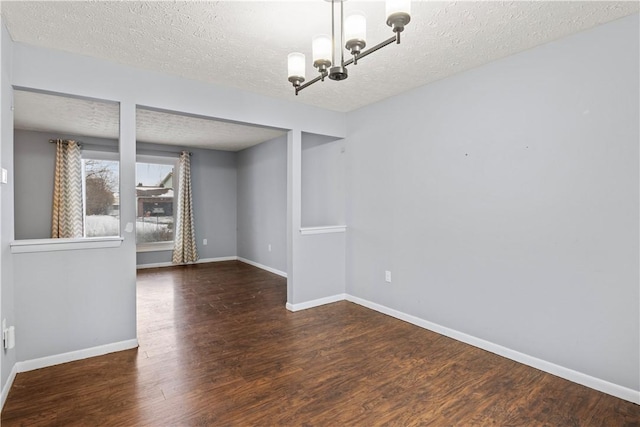 unfurnished dining area with a textured ceiling, a chandelier, and dark hardwood / wood-style floors