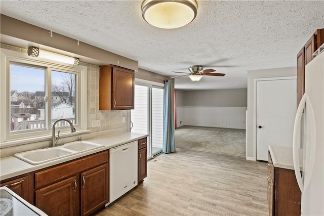 kitchen with a wealth of natural light, ceiling fan, sink, and white appliances