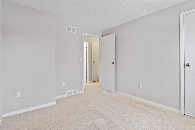 carpeted spare room with a textured ceiling