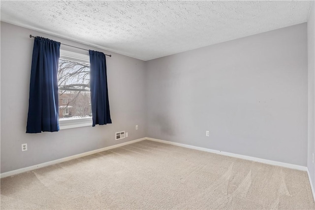 carpeted empty room featuring a textured ceiling