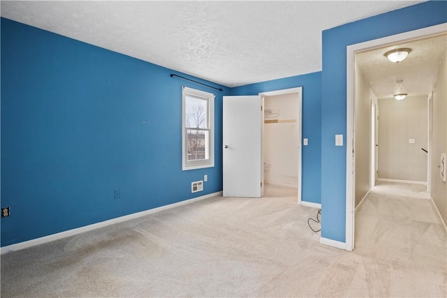 unfurnished bedroom featuring a closet, light colored carpet, and a textured ceiling