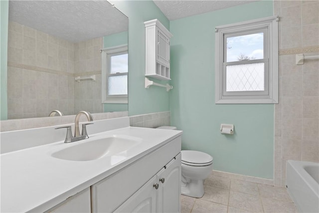 full bathroom featuring vanity, a textured ceiling, tile patterned floors, and plenty of natural light