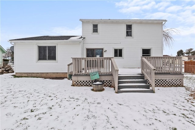 snow covered house with a deck