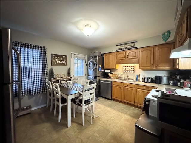 kitchen with stacked washer and dryer, stainless steel appliances, and sink