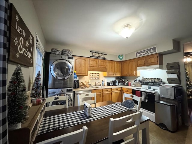 kitchen with stacked washing maching and dryer, sink, and appliances with stainless steel finishes