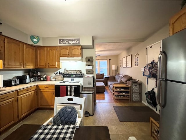 kitchen featuring white electric stove and stainless steel refrigerator