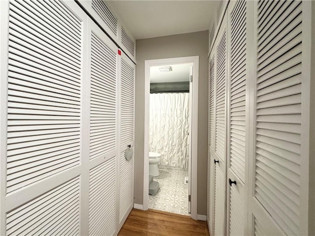 corridor with hardwood / wood-style floors