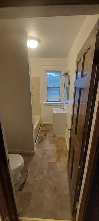 bathroom with vanity, a tub, and toilet