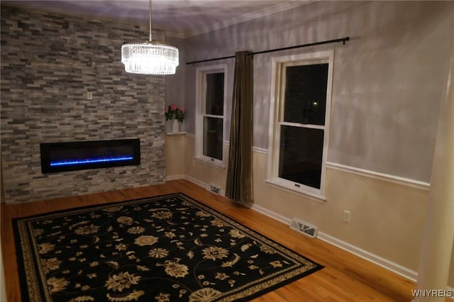 interior space featuring crown molding, wood-type flooring, and a fireplace