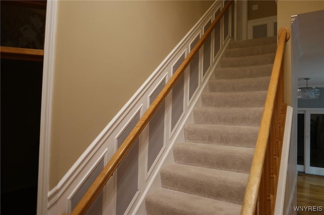 stairs with an inviting chandelier