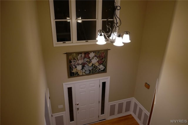 entrance foyer with hardwood / wood-style floors and a notable chandelier