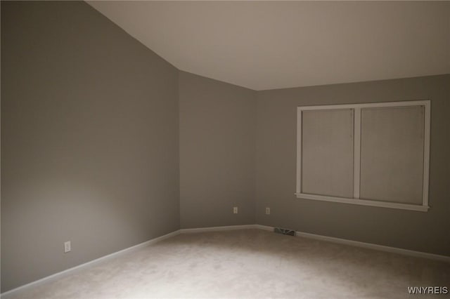 unfurnished room with lofted ceiling and carpet floors