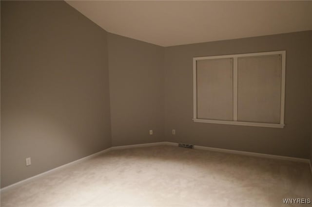 unfurnished room featuring carpet flooring and vaulted ceiling