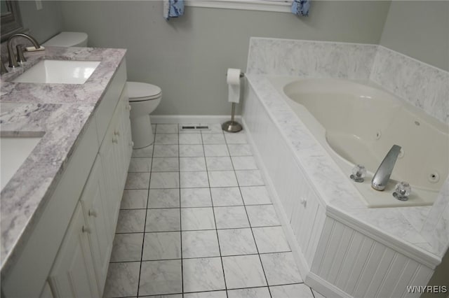 bathroom with tile patterned floors, vanity, toilet, and a bath