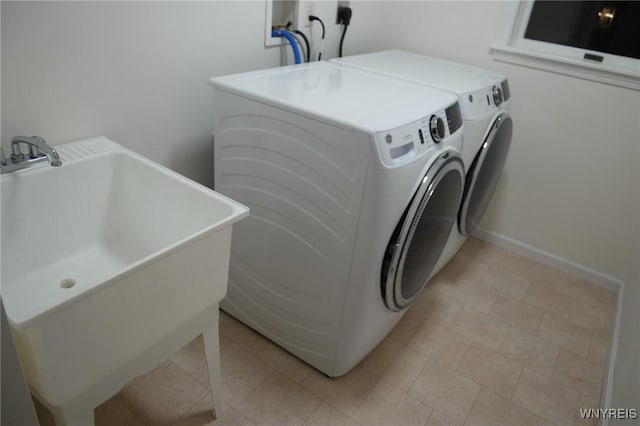 clothes washing area featuring washer and clothes dryer and sink