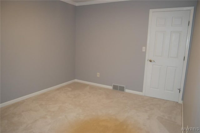 empty room with crown molding and light colored carpet