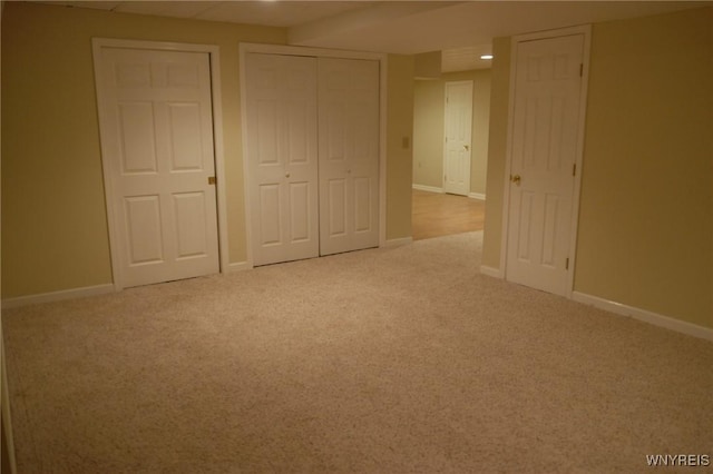 unfurnished bedroom with light carpet and multiple closets