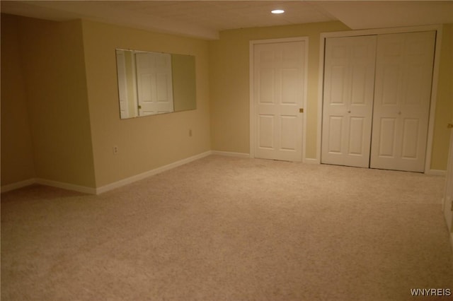 unfurnished bedroom featuring light colored carpet and a closet