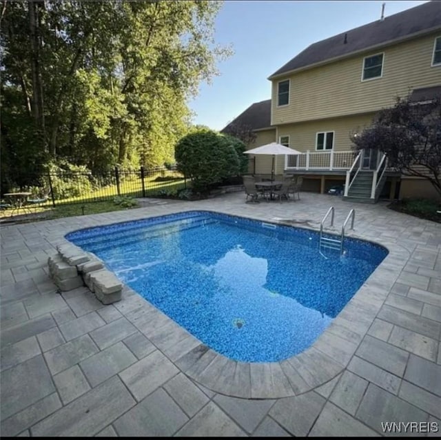 view of swimming pool featuring a wooden deck and a patio area