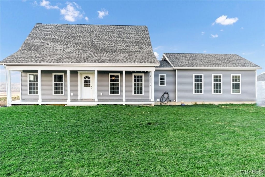 rear view of house featuring a porch and a yard