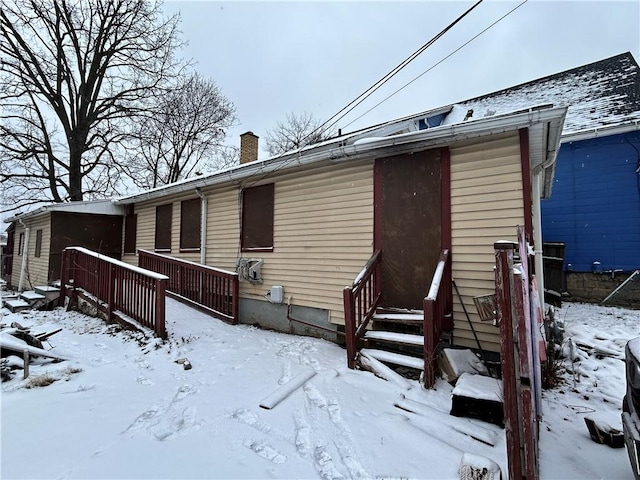 view of snow covered back of property