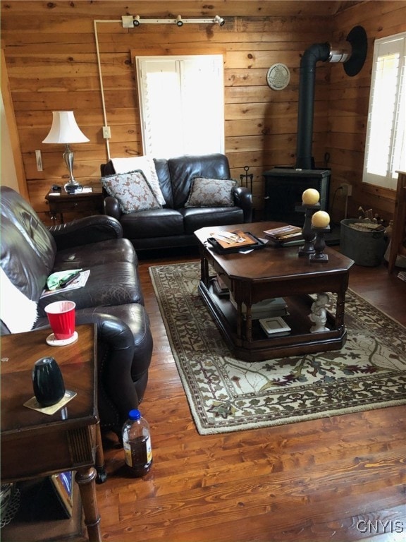 living room with a wood stove, wood walls, and dark hardwood / wood-style flooring