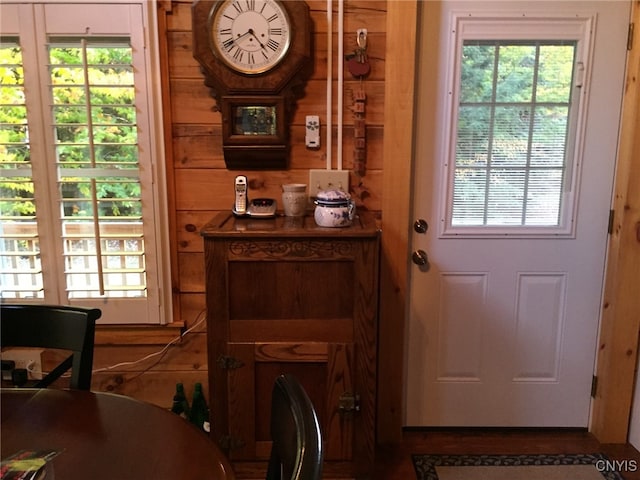 doorway to outside featuring wooden walls