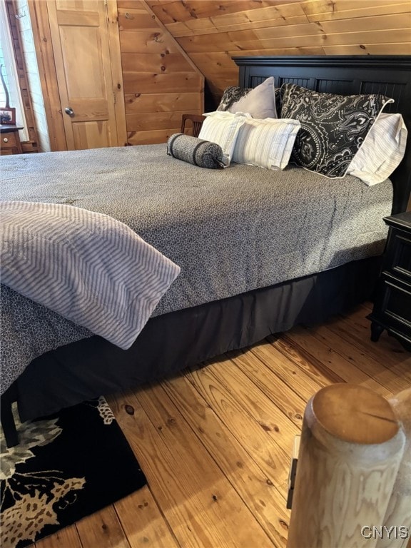 bedroom with hardwood / wood-style flooring, vaulted ceiling, and wooden ceiling