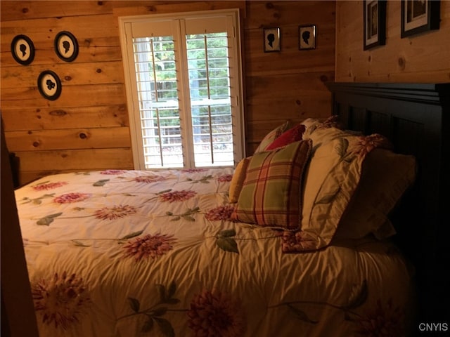 bedroom featuring wooden walls