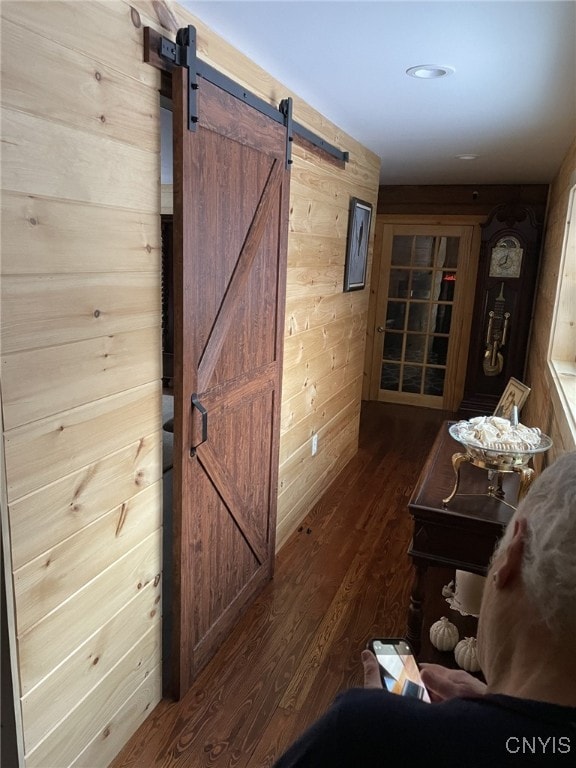 interior space featuring a barn door, wood walls, and wood-type flooring